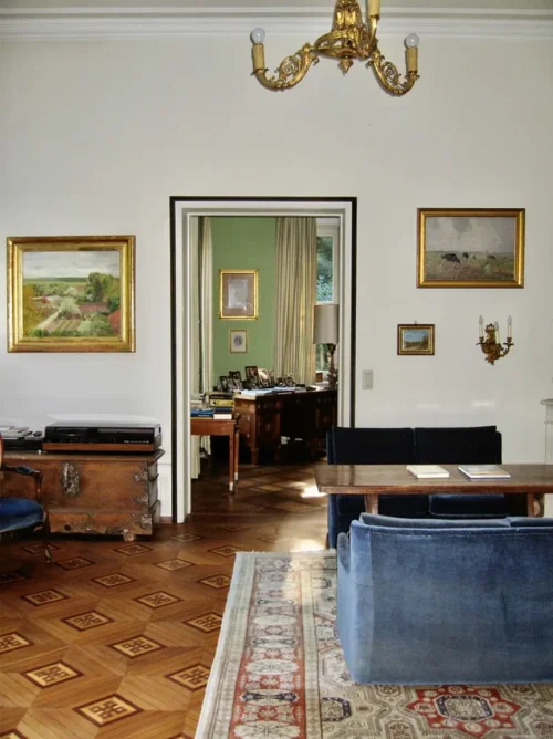 Wohnzimmer mit Mosaikparkett Teppich Tisch und Couch